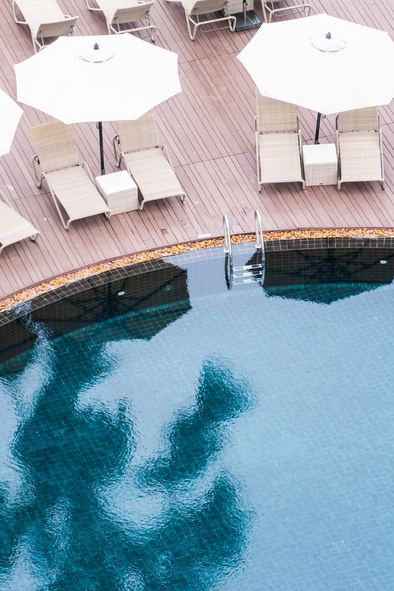Umbrella and chairs arranged around a backyard pool